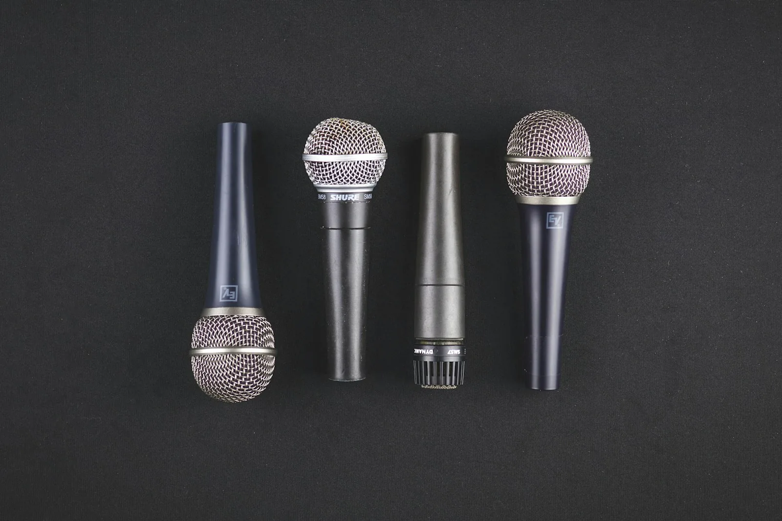 Four microphones lined up at a podium