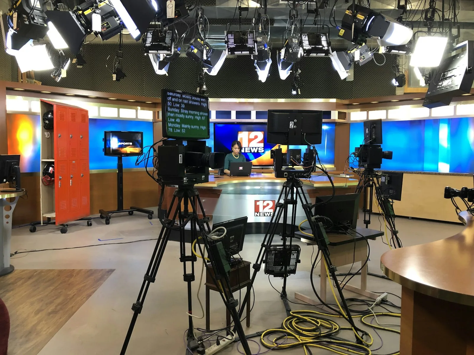Cameras set before an empty television news desk